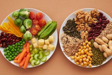 A vibrant flatlay of colorful vegetables and nuts showcasing a balanced diet concept.