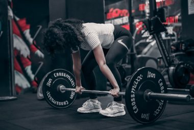 a woman lifting a barbell in a gym